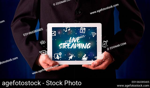 Young business person working on tablet and shows the inscription: LIVE STREAMING