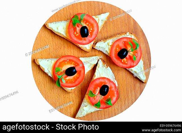 Sandwiches with red tomato, olives and arugula on the cutting Board