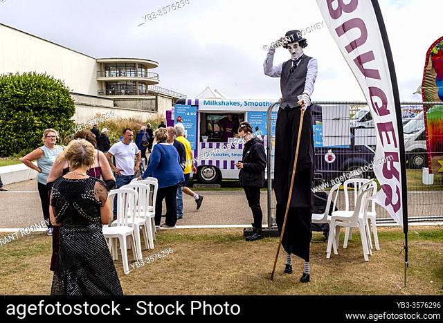 A Man On Stilts Dressed As Charlie Chaplin At The Great Gatsby Fair, Bexhill on Sea, East Sussex, UK