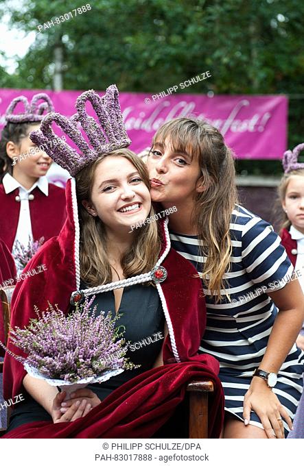 18-year-old Marie-Louisa Sebastian (m) smiles with her sister and heather queen of 2013, Lara-Sophie Wedekind (r), after her election as the new heather queen...