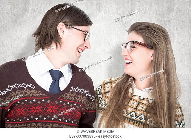 Composite image of happy geeky hipster couple looking at each other