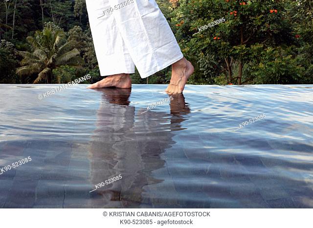 Man's feet on the edge of an outdoor pool at Losari Coffee Plantation in West Java, Indonesia, South East Asia