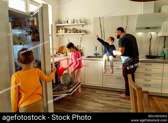 Children with father in kitchen at home