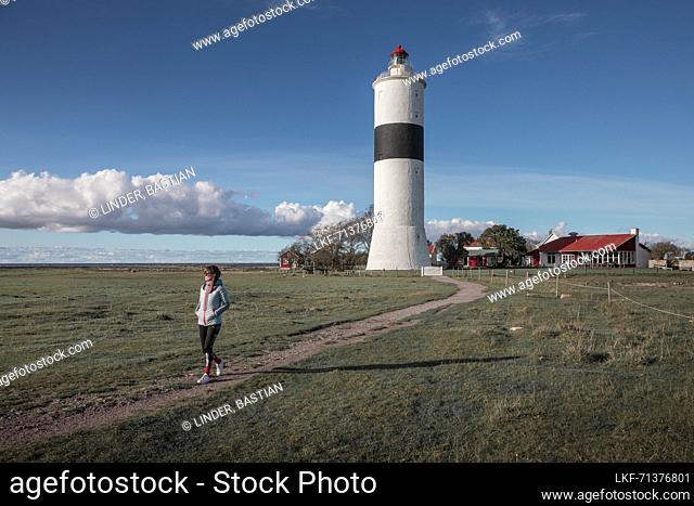 Woman at the Långe Jan lighthouse in the south of the island of Öland in Sweden with a blue sky