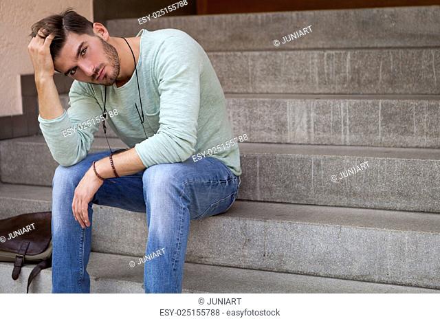 Casual young man sitting on steps