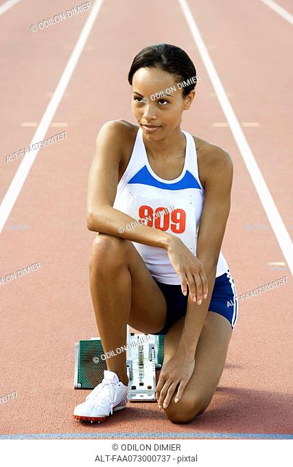 Female runner crouched at starting line