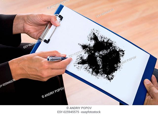 Close-up Of A Psychologist Showing Rorschach Inkblot On Clipboard To Patient