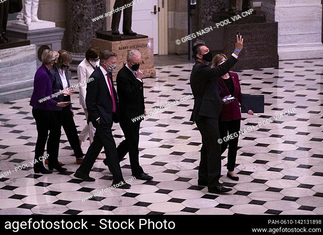 Sen. Alex Padilla (D-Calif.) takes a selfie with fellow Senators as he walks through Statuary Hall in the U.S. Capitol in Washington, D.C