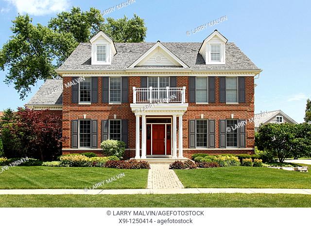 Brick home with columned entry and front balcony