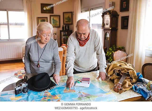 Elderly couple planning a trip on a map. Barcelona, Spain
