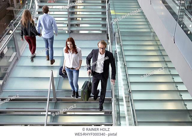 Germany, Cologne, People walking up and down stairs with baggage at airport