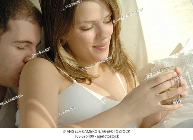 Young couple together in bed being intimate