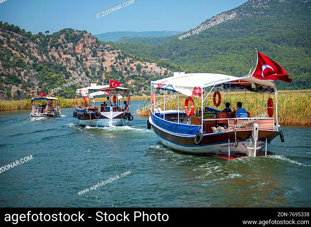 TURKEY, DALYAN, MUGLA - JULY 19, 2014: Touristic River Boats with tourists in the mouth of the Dalyan River
