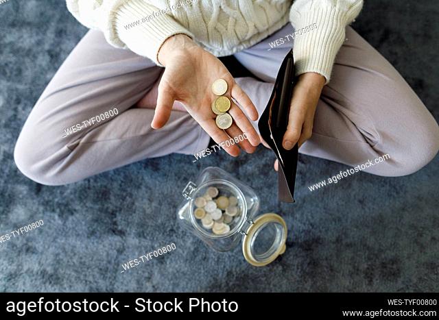 Hand of woman counting coins at home
