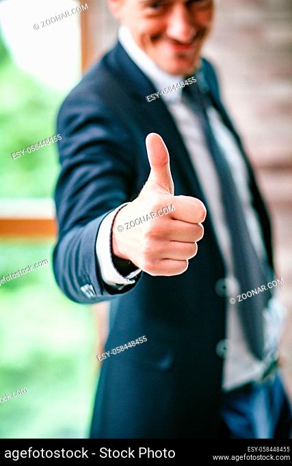 Smiling Male Office Worker Showing Thumb Up. Happy After Successful Project Start. Selective Focus On Thumb Up