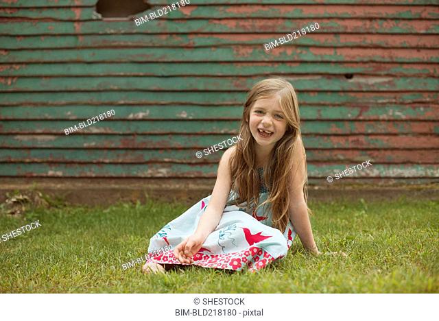 Caucasian girl sitting in backyard