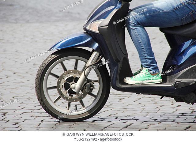 teenager riding scooter moped in rome italy
