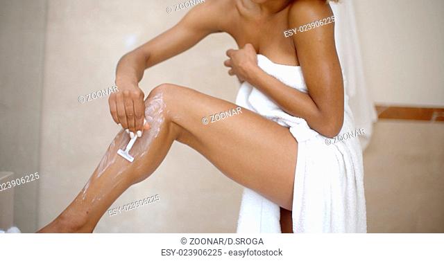 Young Woman Is Shaving Her Leg