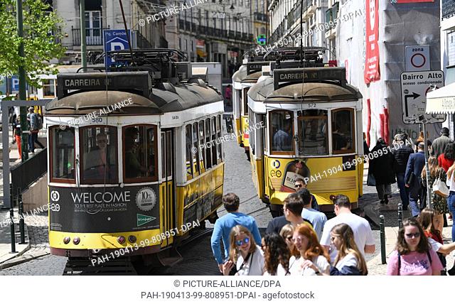 12 April 2019, Portugal, Lissabon: Trams number 24 (l) and 28 go through Praca Luis de Comoes. The central square in the centre of Lisbon connects the districts...