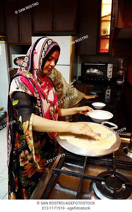 Oman, Sultanat, Middle East, Muscat, women fixing bread in the kitchen for lunch and having lunch, Hamza-Hayyat family