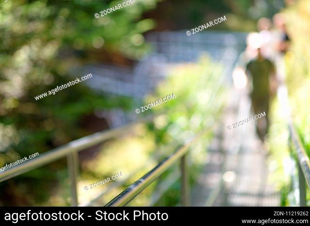 steel suspension footbridge in mountains - image with natural extremely shallow depth of field - ready for background