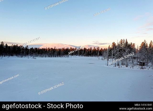 huts in the forest, snow-covered lake, behind the pallastunturi, yli-kyrö, lapland, finland