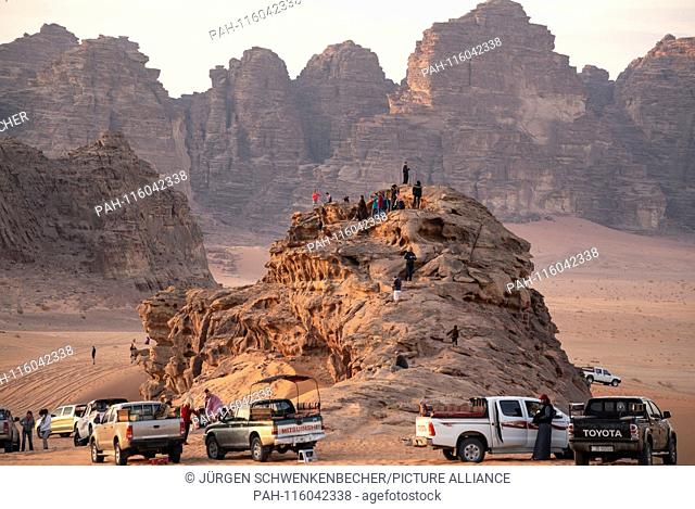 Tourists have climbed a rock in the Wadi Rum desert (Jordan) to watch a sunset. (06 November 2018) | usage worldwide. - Wadi Rum/Jordan