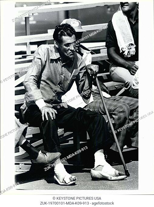 Jan. 1, 1970 - This man, who said that his legs and arms had been injured by dogs in Cuba, sits on bleachers as he waits for the first church service to be...