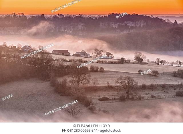 View of farmland and river shrouded in mist at sunrise, Lower Wyndcliff, Chepstow, River Wye, Lower Wye Valley, Monmouthshire, Wales, May