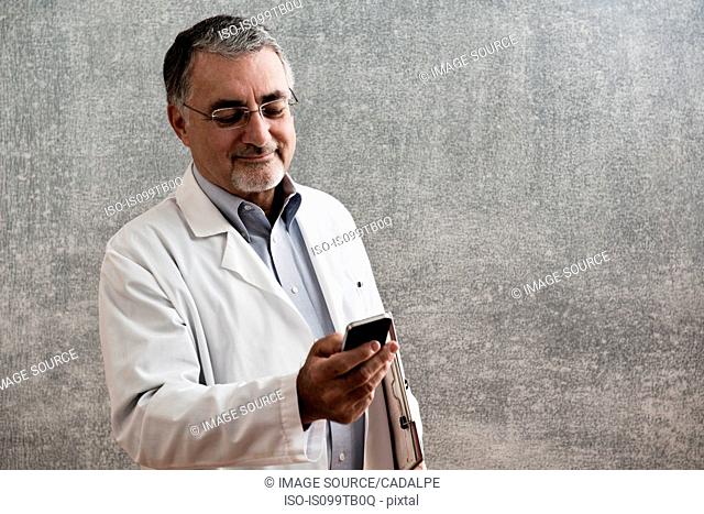 Male doctor looking at cellphone