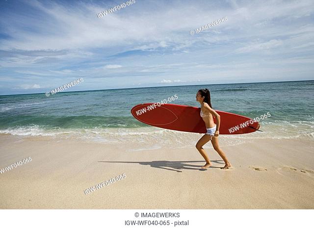Portrait of a young woman running on beach