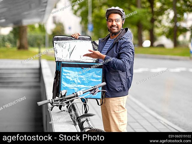 man with food delivery bag and bicycle in city
