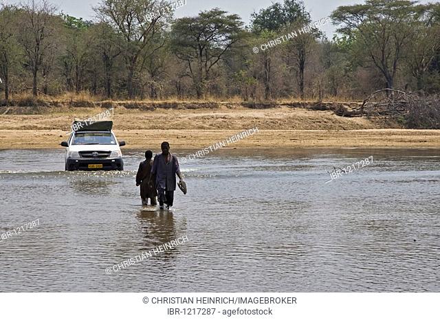 Fisherman showing an all-terrain vehicle the ford of the river Luangwa, North Luangwa National Park, Zambia