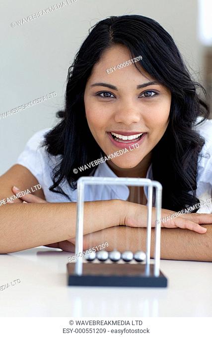 Businesswoman playing with Newton balls in office