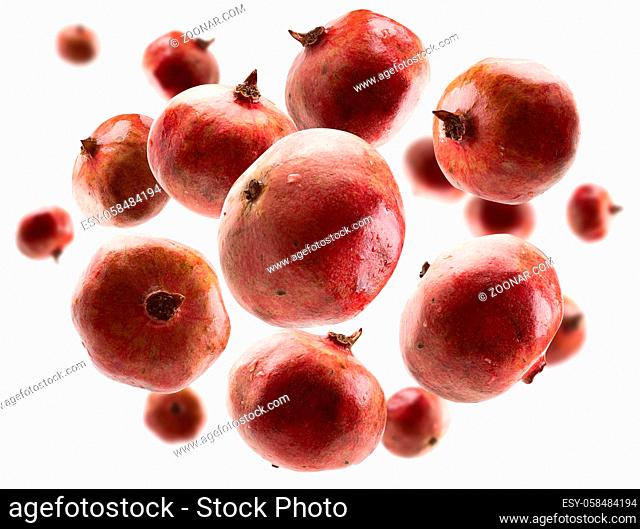 Ripe pomegranates levitate on a white background
