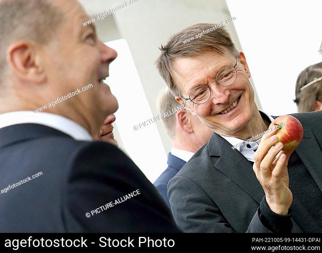 05 October 2022, Berlin: Chancellor Olaf Scholz (SPD, l) and Karl Lauterbach (SPD), Federal Minister of Health, are presented with apples before the cabinet...