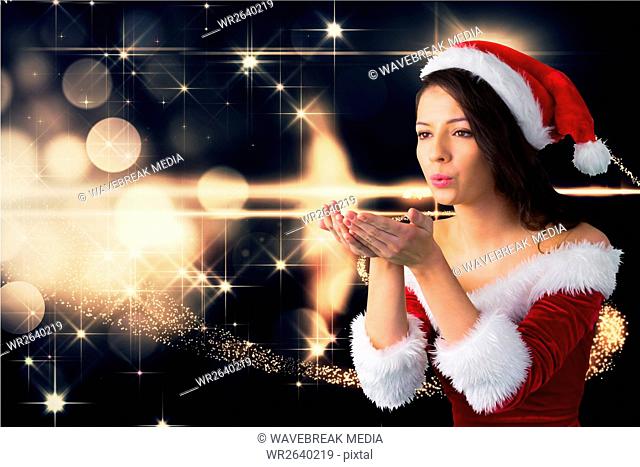 Beautiful woman wearing santa costume blowing a kiss against digitally generated christmas backgroun