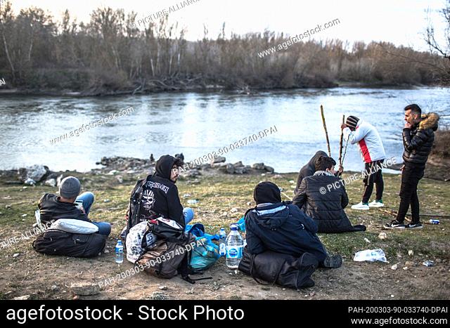 03 March 2020, Turkey, Edirne: Refugees wait on Evros river bank, near Edirne, in northwestern Turkey, to take a boat to attempt to enter Greece by crossing the...