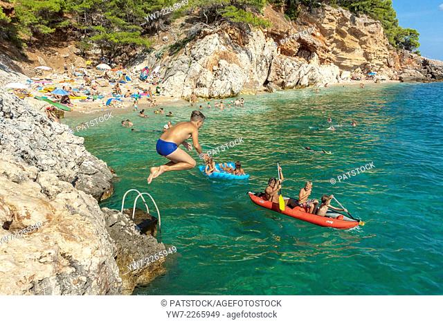 Boy jumping into the Adriatic sea in Jagodna village, Hvar island, Croatia
