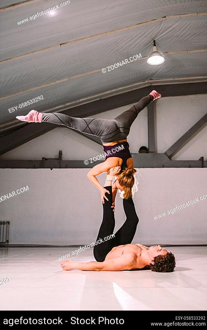 Yogi couple practice. Couple young sporty peoplepracticing acrobatic yoga lesson with partner, man and woman in yogi exercise, arm balance pose