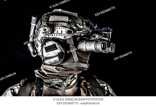 Modern army special forces soldier, anti terrorist squad fighter, elite commando warrior wearing mask, using four lenses night vision goggles in low light...