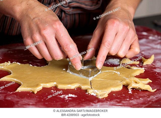 Woman cutting cookie shapes out of dough