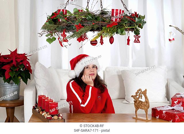 Girl in living room with Christmas decoration looking up