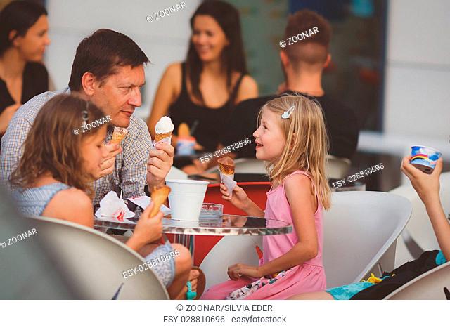 Father and daughters eating ice cream