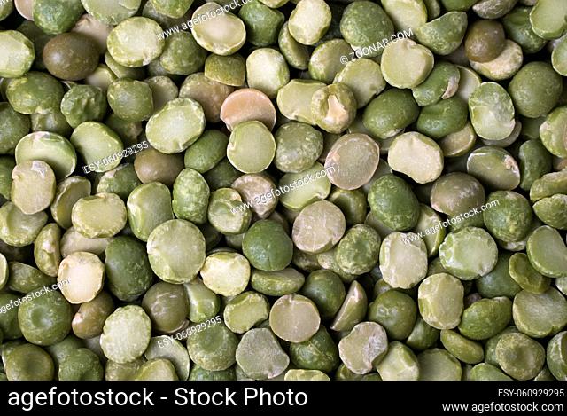 A background of split dry green peas, close up view