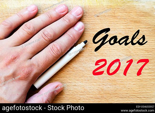 Human hand over wooden background and goals 2017 text concept