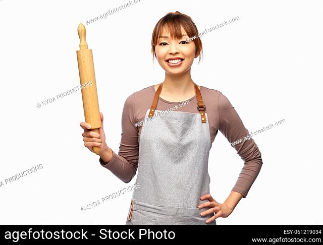 happy woman in apron with wooden rolling pin