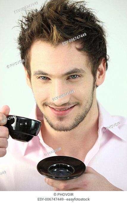 Smiling man drinking a cup of coffee