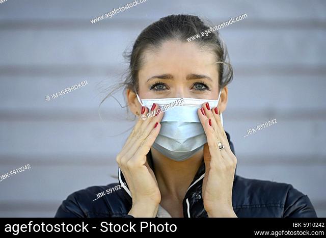 Woman puts on a face mask, moves her, portrait, corona crisis, Stuttgart, Baden-Württemberg, Germany, Europe