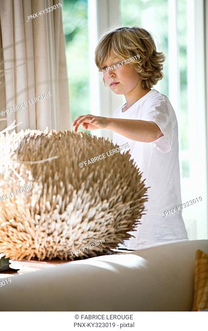 Boy touching a round shape object at home